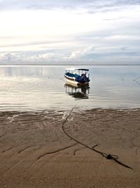 Boat moored on sea against sky