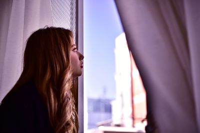 Portrait of woman looking through window