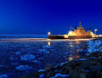 Scenic view of frozen sea against clear blue sky at night