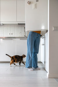 Side view of man with dog on floor at home
