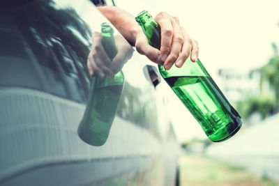 Close-up of hand holding glass bottle