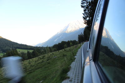 Scenic view of mountains against sky seen through car window