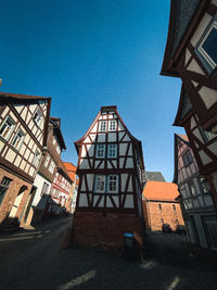 Low angle view of buildings against clear blue sky