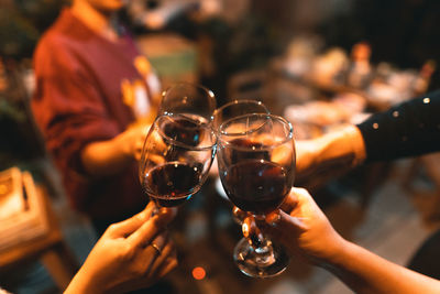 Midsection of people holding wine glasses during party