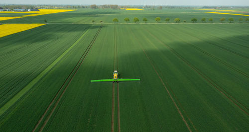 Tractor with field sprayer when applying pesticide against pesticide