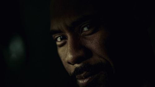 Close-up portrait of young man against black background