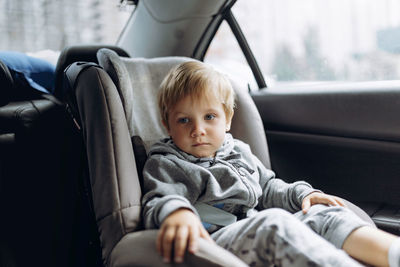 Cute boy sitting in car