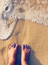 Low section of person on sand at beach