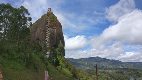 Low angle view of cross on mountain against sky