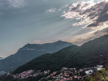 Aerial view of townscape by mountains against sky