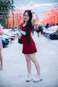 Full length portrait of woman standing on street in city