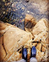 Low section of man standing on rock