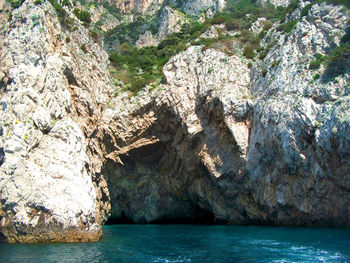 Rock formations by sea against sky
