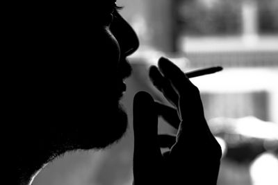 Side view of man holding cigarette
