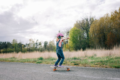 Young girl learning to skateboard on her own