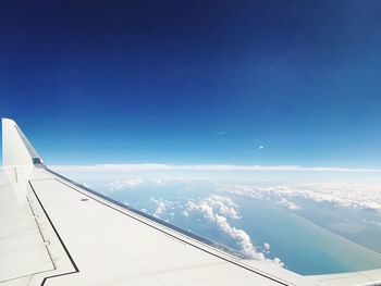 Airplane flying over clouds against blue sky