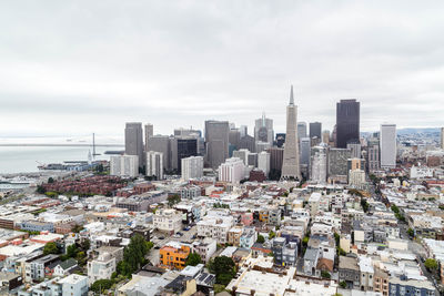 Aerial view of buildings in city against sky