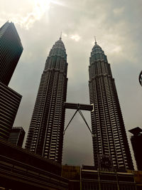 Low angle view of buildings against cloudy sky