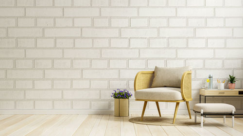 Living room interior room brick wall mockup in warm tones,gray armchair on wooden flooring.