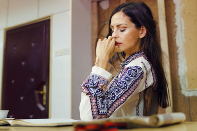 Woman looking away while standing on table