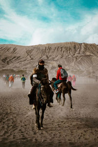 People riding motorcycle on desert