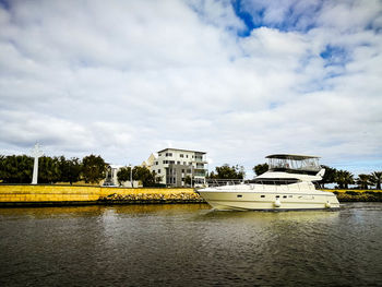 Scenic view of river by buildings against sky