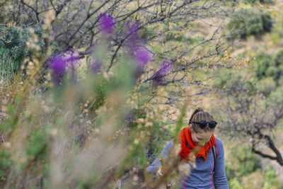 Woman walking against tree