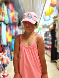 Portrait of cute girl wearing cap while standing at store