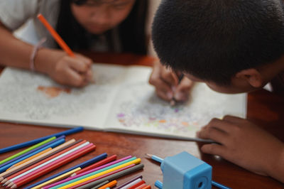 Brother and sister paint the art book together