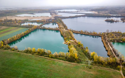 High angle view of lakes devided by road and trees