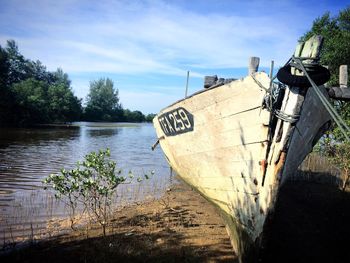 Abandoned boat moored in lake against sky