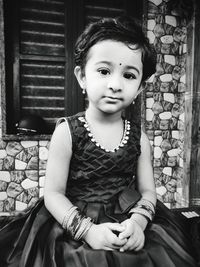 Portrait of cute girl sitting outdoors