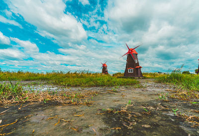 Traditional windmill on field against sky