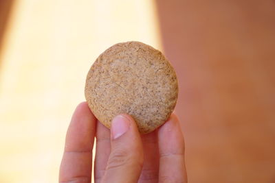 Close-up of hand holding apple against stone