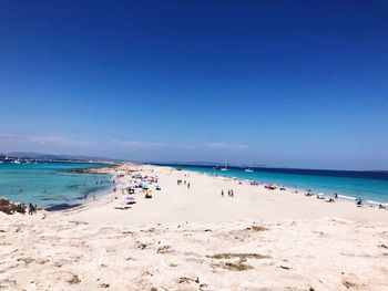 Scenic view of beach against clear blue sky