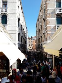 Crowd in city against clear sky