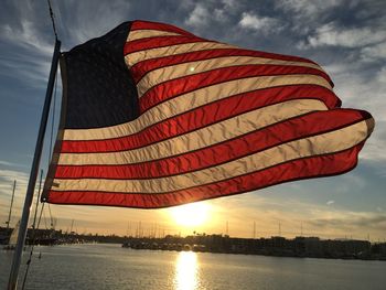 Low angle view of flag against sky during sunset