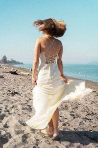 Rear view of woman standing at beach