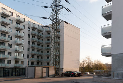 Cars on road by buildings against sky