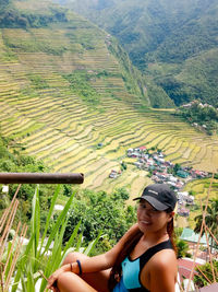 Portrait of smiling young woman standing on agricultural field