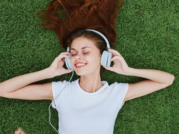 High angle view of young woman sitting on grassy field