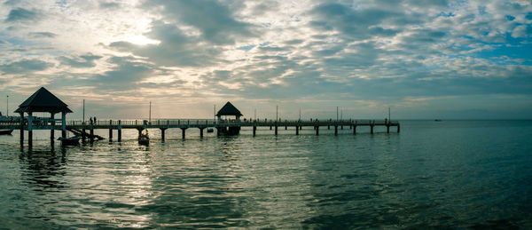 Pier on sea against sky during sunset