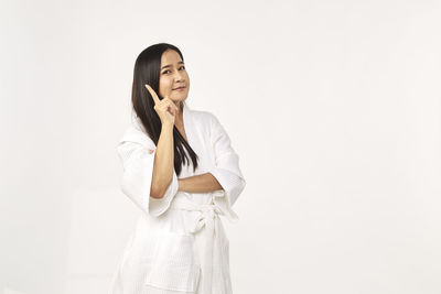 Young woman looking away against white background