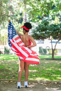 Low section of woman holding red umbrella