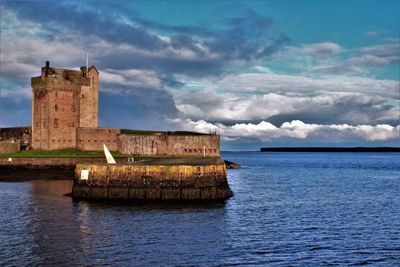 Castle by sea against sky