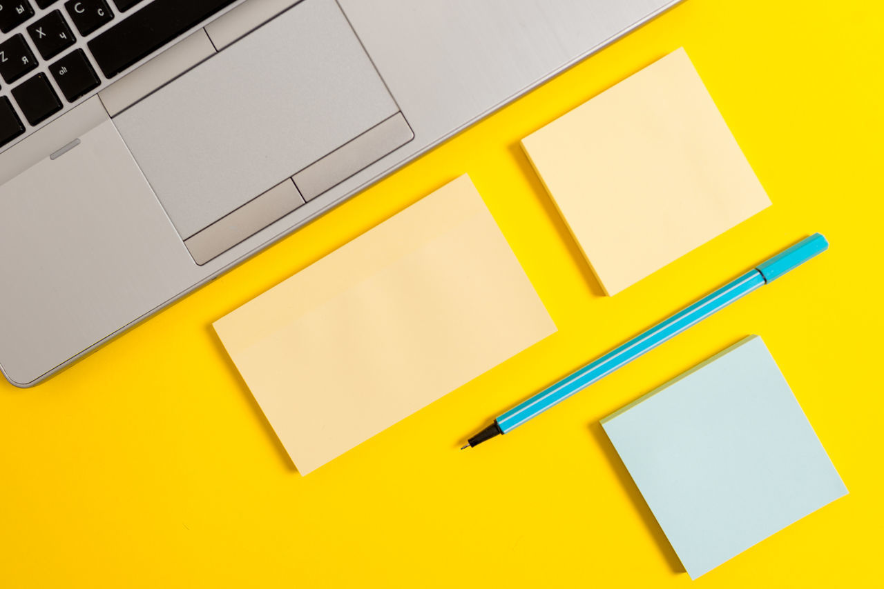 HIGH ANGLE VIEW OF YELLOW TELEPHONE ON PAPER