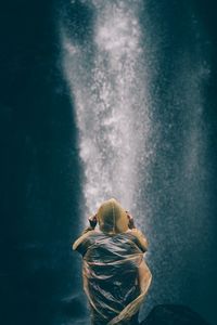 Rear view of woman standing in water