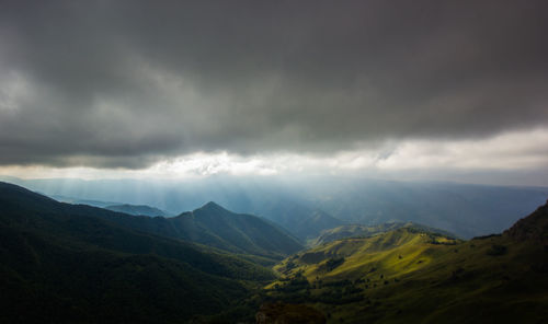 Scenic view of mountains against cloudy sky