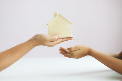 Close-up of hand holding paper against white background