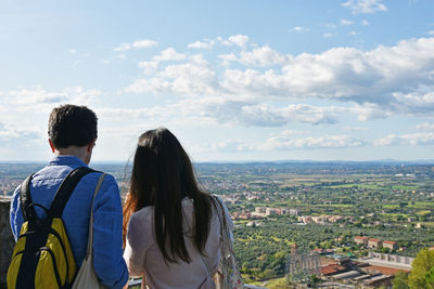 Rear view of couple against cityscape and sky